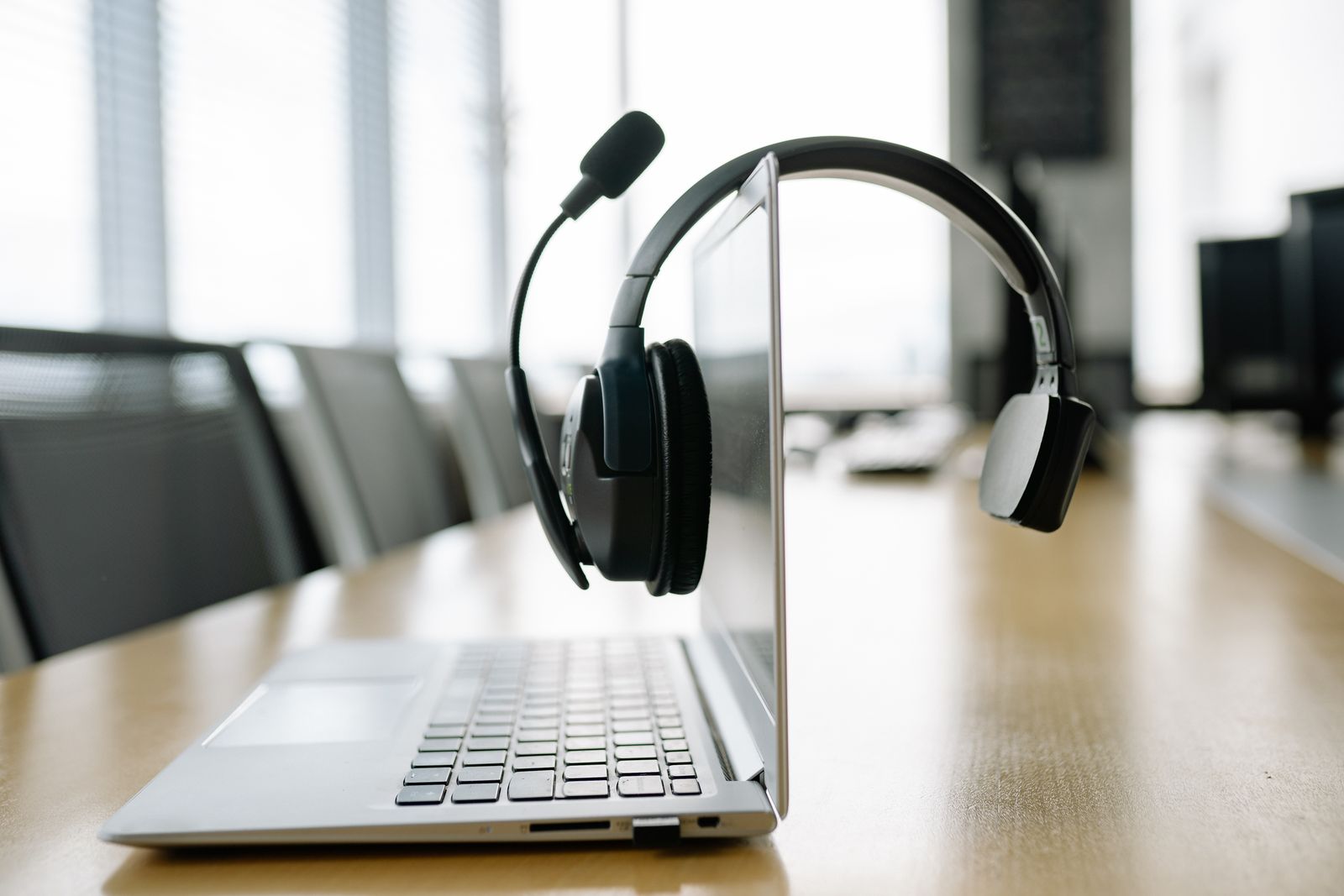 Casque VoIP pos&eacute; sur un bureau, salle de r&eacute;union moderne, FBI Services